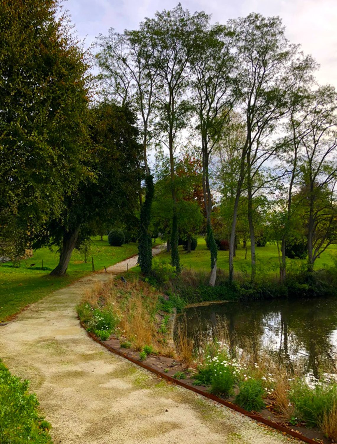 Chemin arboré longeant l'étang du jardin historique